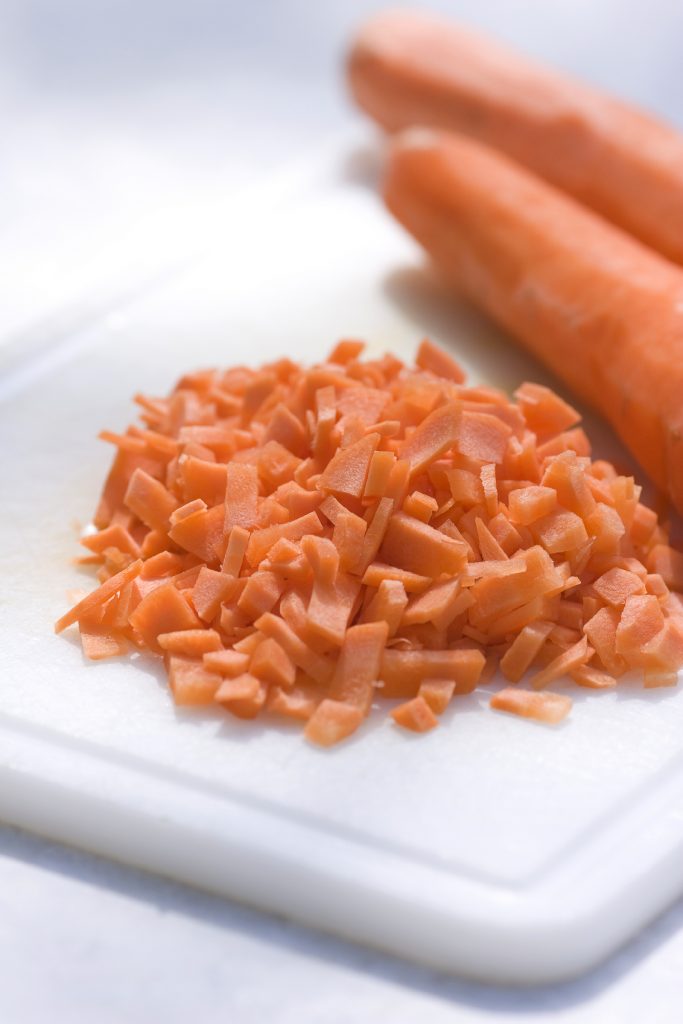 Close-up of finely chopped carrots on a cutting board