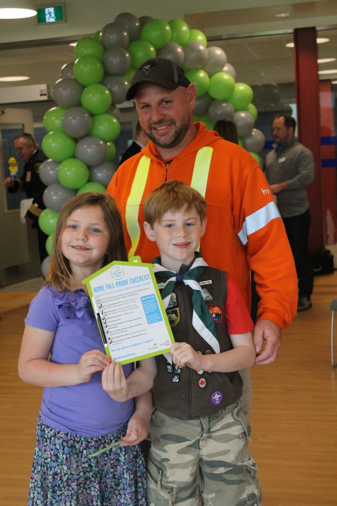 Man with kids holding home fall proof checklist