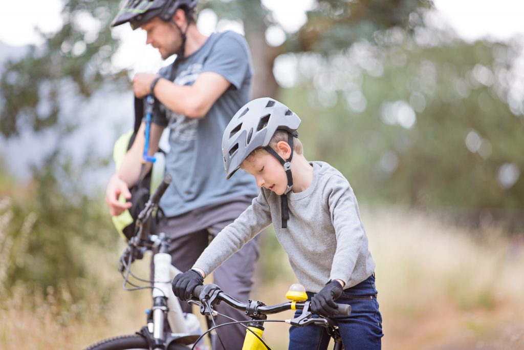 Close-up of a child with a properly fitted helmet on a bike
